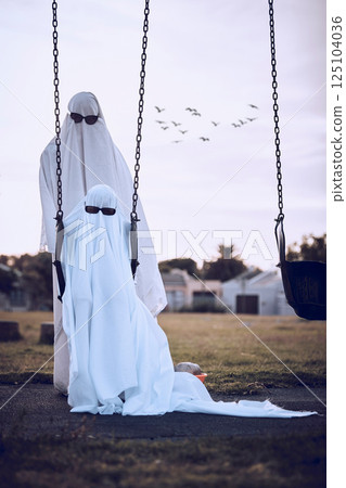 Halloween, ghost costumes and sunglasses in the park for scary family holiday celebration together. Father or mother with child playing spooky dress up wearing sheets to terrorize the neighborhood Halloween, ghost costumes and sunglasses in the park for scary family holiday celebration together. Father or mother with child playing spooky dress up wearing sheets to terrorize the neighborhood 125104036