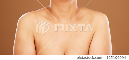 Woman, chest and skincare on a brown studio background for health, wellness and breast cancer awareness. Human body, skin and bust of a female model posing naked for healthcare and self care Woman, chest and skincare on a brown studio background for health, wellness and breast cancer awareness. Human body, skin and bust of a female model posing naked for healthcare and self care 125104094