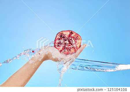 Water splash, hand and pomegranate for health in studio on blue background mockup. Fresh fruits, cleaning hygiene and female model holding fruit food for vitamin c, organic cosmetics or glowing skin. Water splash, hand and pomegranate for health in studio on blue background mockup. Fresh fruits, cleaning hygiene and female model holding fruit food for vitamin c, organic cosmetics or glowing skin. 125104108
