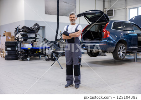 Professional technician in auto shop checking vehicle Professional technician in auto shop checking vehicle 125104382