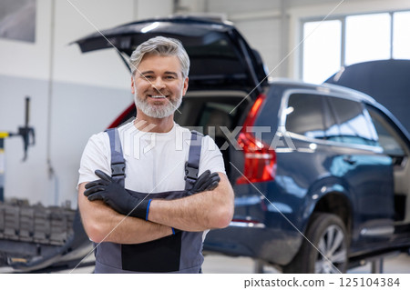 Man in uniform working indoors in garage 125104384