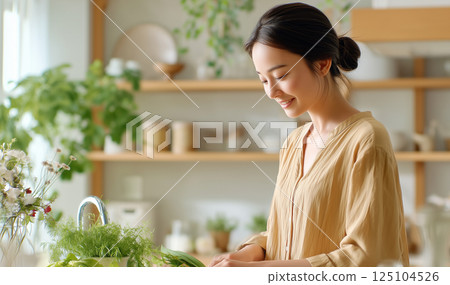 A woman cooking in a kitchen with natural light 125104526