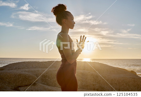 Yoga, meditation or sunset with woman in peace by the ocean, sea or beach for wellness, zen or chakra balance. Spiritual, health or fitness girl on rock or sand for mindset goal, pilates or workout 125104535