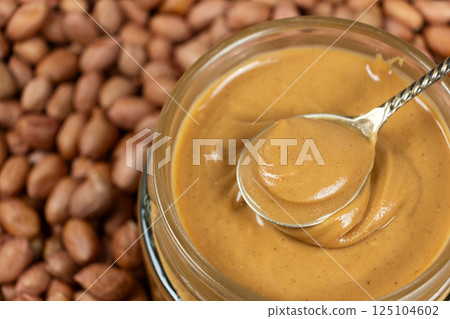 Peanut Butter in Spoon with Crunchy Peanut Background 125104602
