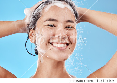 Hair shampoo, portrait and woman in shower in studio isolated on a blue background. Hygiene, water splash and healthy female model from Canada cleaning, bathing and washing for wellness and hair care 125105106