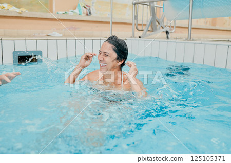 Retirement, happy and wellness woman swimming in pool for pension leisure fun with smile. Cardio health lifestyle of senior person in swimming pool for exercise, fitness and happiness. Retirement, happy and wellness woman swimming in pool for pension leisure fun with smile. Cardio health lifestyle of senior person in swimming pool for exercise, fitness and happiness. 125105371