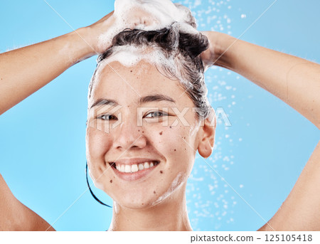 Woman, shampoo and shower in studio portrait with hair care, cleaning and smile by blue background. Model, hair and wellness with foam, soap or water for self care, cosmetics or beauty with happiness Woman, shampoo and shower in studio portrait with hair care, cleaning and smile by blue background. Model, hair and wellness with foam, soap or water for self care, cosmetics or beauty with happiness 125105418