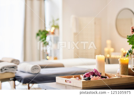Candle, spa and relax with aromatherapy treatment in a tray in a room for luxury or wellness. Background, health and massage with still life in an empty resort for peace, skincare or relaxation Candle, spa and relax with aromatherapy treatment in a tray in a room for luxury or wellness. Background, health and massage with still life in an empty resort for peace, skincare or relaxation 125105975
