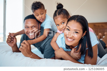 Happy, smile and portrait of a family in a bedroom to relax, play and bond together at their home. Happiness, love and parents relaxing with their children while being playful on a bed at their house 125106005