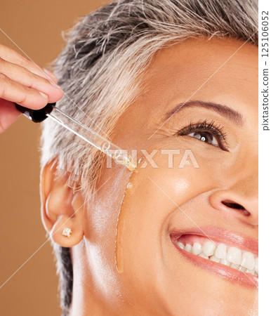 Skincare, serum and face of senior woman with liquid product for glowing skin hydration, anti aging or facial skin protection. Elderly beauty model with spa cosmetics, collagen oil or hyaluronic acid 125106052