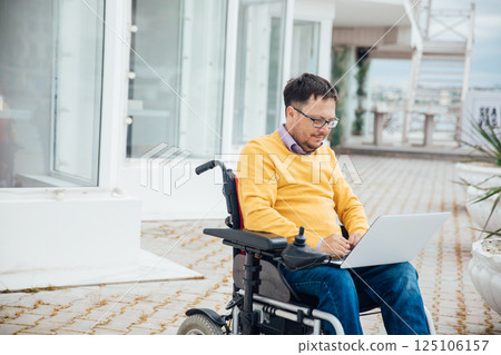 Man in wheelchair working with laptop negotiating business Man in wheelchair working with laptop negotiating business 125106157