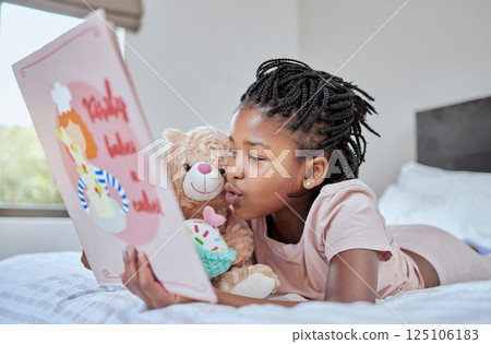 Reading, book and teddy bear with a black girl in bed, lying down to relax in the bedroom with her hobby. Children, books and education with a female kid telling her teddybear a story in their home Reading, book and teddy bear with a black girl in bed, lying down to relax in the bedroom with her hobby. Children, books and education with a female kid telling her teddybear a story in their home 125106183