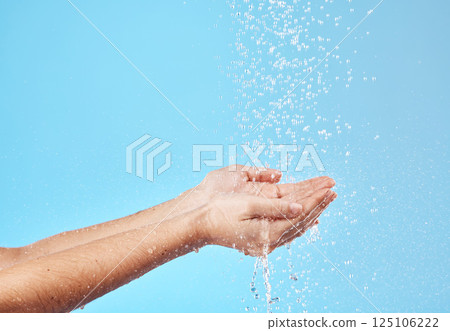 Shower, water and hands of a woman cleaning, saving and catching liquid against blue studio background. Sustainability, wellness and person with care for body, grooming and hygiene with mockup space 125106222