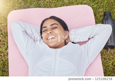 Happy woman lying on exercise mat in park, garden and grass field for peace, sleep and motivation for workout, training and fitness. Indian girl rest on yoga mat in nature, wellness and healthy life 125106238