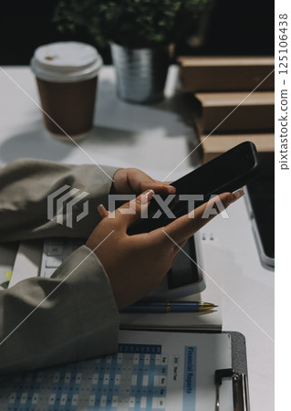 Asian Businesswoman Using laptop computer and working at office with calculator document on desk, doing planning analyzing the financial report, business plan investment, finance analysis concept. 125106438