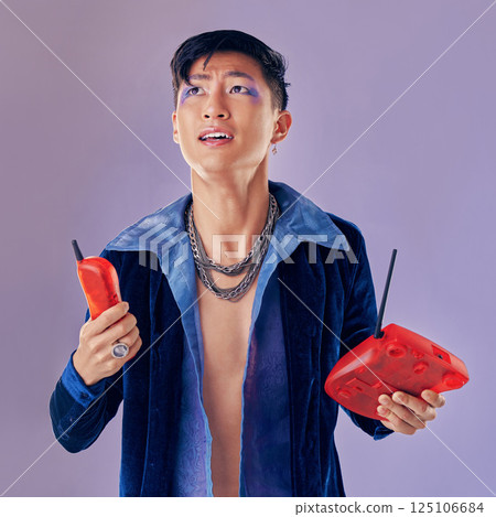 Fashion, telephone and confused man in studio isolated on a purple background. Gen z punk, phone call decline and gay model from Japan in makeup with retro, vintage phone and outdated technology. Fashion, telephone and confused man in studio isolated on a purple background. Gen z punk, phone call decline and gay model from Japan in makeup with retro, vintage phone and outdated technology. 125106684