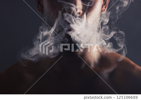Smoke, cloud and face of man with pollution for marijuana smoker health campaign with zoom. Cannabis, weed and cbd addiction model for smoking habit lifestyle advertising in black studio. Smoke, cloud and face of man with pollution for marijuana smoker health campaign with zoom. Cannabis, weed and cbd addiction model for smoking habit lifestyle advertising in black studio. 125106689