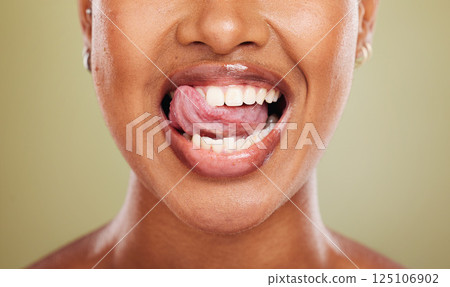 Tongue, teeth and african woman in closeup with lick, smile or happy for dental wellness in studio. Model, mouth or perfect teeth whitening for health, medical or beauty by background in healthcare 125106902
