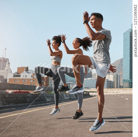 Exercise, friends and jump training in city for health, wellness and fitness. Sports, people and teamwork of runner group in street exercising, workout and jumping practice outdoors on urban road. 125106982