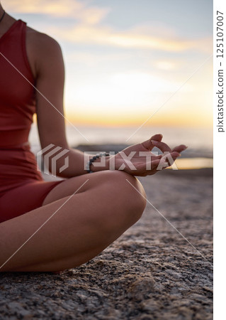 Hand, woman and yoga at the beach at sunset, zen and relax exercise, mudra and chakra training with mockup. Meditation, hands and girl meditating at the sea, peace and energy in nature environment 125107007