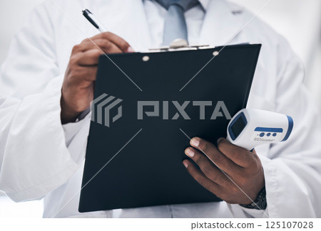 Covid, doctor with thermometer and clipboard writing on patient chart or medical insurance documents. Research, innovation in healthcare and black man with paperwork in hands for safety in hospital. Covid, doctor with thermometer and clipboard writing on patient chart or medical insurance documents. Research, innovation in healthcare and black man with paperwork in hands for safety in hospital. 125107028