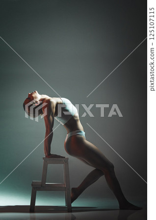 Dance, chair and woman doing a performance in a studio for training or a concert with mockup space. Sexy, entertainment and girl dancing or moving for a theater show isolated by a gradient background 125107115