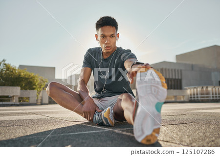 Fitness, earphones and man stretching hamstring in city for training, exercise or cardio workout or health warm up. Wellness, male and listening to music with healthy workout outdoor in summer 125107286