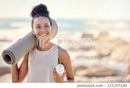 Happy black woman, fitness and smile for yoga in preparation for training, exercise or workout at the beach. Female smiling in spiritual wellness holding sports mat for calm, zen and exercising day Happy black woman, fitness and smile for yoga in preparation for training, exercise or workout at the beach. Female smiling in spiritual wellness holding sports mat for calm, zen and exercising day 125107299