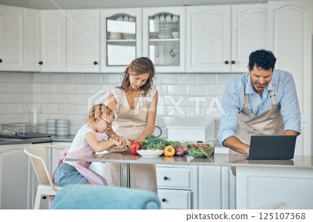 Kitchen, cooking and family with laptop with vegetables, food nutrition information and internet recipe search for healthy, vegan lifestyle. Parents and child learning together for lunch or dinner 125107368