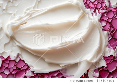 Creamy whipped topping displayed in a round container with smooth texture and swirls 125107404