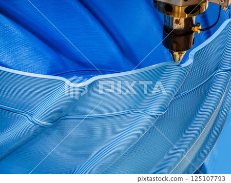 Advanced 3D printing process creates intricate blue patterns in a flexible material on a production line Advanced 3D printing process creates intricate blue patterns in a flexible material on a production line 125107793