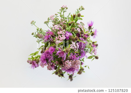 Bouquet of wild purple flowers on grey background. View from above. Close up. 125107820