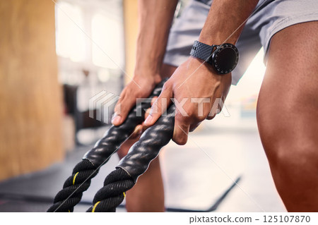 Hands, fitness and battle rope with a sports man training for cardio or endurance in a gym workout. Grip, heavy ropes and exercise with a male athlete holding equipment for a healthy, strong body Hands, fitness and battle rope with a sports man training for cardio or endurance in a gym workout. Grip, heavy ropes and exercise with a male athlete holding equipment for a healthy, strong body 125107870