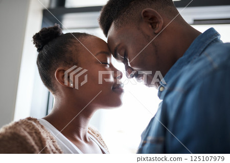 Black couple, relax and forehead for love, care or relationship bonding together at home. African American man and woman touching heads in loving embrace for caring moment, trust or support indoors 125107979