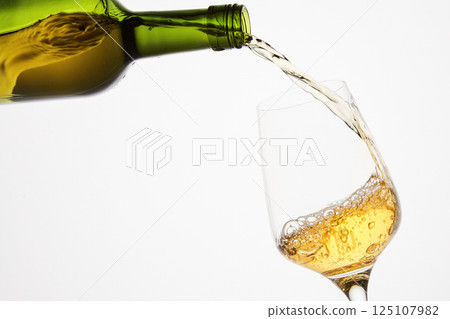 White sparkling wine pouring from green bottle. White sparkling wine pouring from green bottle. 125107982