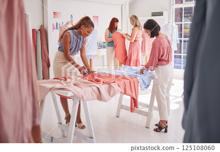 Business people, fashion and design working with fabric, material or clothing in teamwork at the office. Group of employee designers busy with garment or outfit together on team project in the studio 125108060