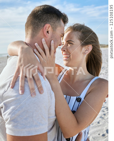 Love, couple close and hug on beach with smile, romantic and on sand being loving, on holiday and together. Romantic man and woman embrace for relationship, getaway and seaside vacation to celebrate. 125108195