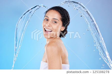 Water, splash and hygiene with a model black woman in the studio shower on a blue background for hygiene. Portrait, face and water splash with an attractive young female cleaning in the bathroom Water, splash and hygiene with a model black woman in the studio shower on a blue background for hygiene. Portrait, face and water splash with an attractive young female cleaning in the bathroom 125108278