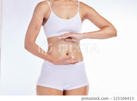 Hands, body and health with a model woman frame her stomach in studio on a gray background for wellness. Weightloss, tummy and diet with a female posing to promote healthy eating or nutrition Hands, body and health with a model woman frame her stomach in studio on a gray background for wellness. Weightloss, tummy and diet with a female posing to promote healthy eating or nutrition 125108413