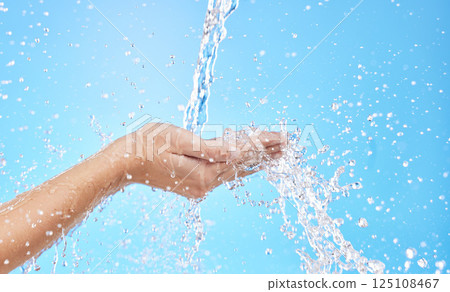 Hands, water splash and cleaning skin, bacteria and hygiene for blue studio background with mockup space. Hand rinsing, washing or clean for fresh hygienic cleanse or hydration in care for skincare 125108467