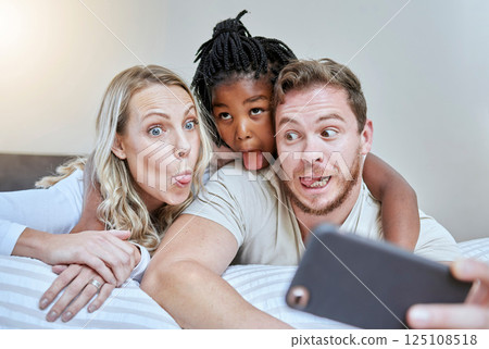 Child, parents or comic face for phone selfie in house, hotel or home bedroom on social media, memory vlog or fun. Mother, father or black girl on mobile photography technology with tongue expression Child, parents or comic face for phone selfie in house, hotel or home bedroom on social media, memory vlog or fun. Mother, father or black girl on mobile photography technology with tongue expression 125108518