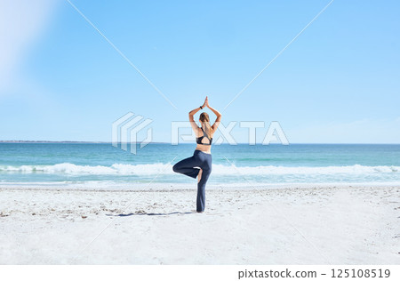 Yoga, woman and at beach on sand, meditation and relax for wellness, calm and peace. Zen, female and lady with balance, exercise and pilates for training, fitness or breathing on seaside and outdoor. 125108519