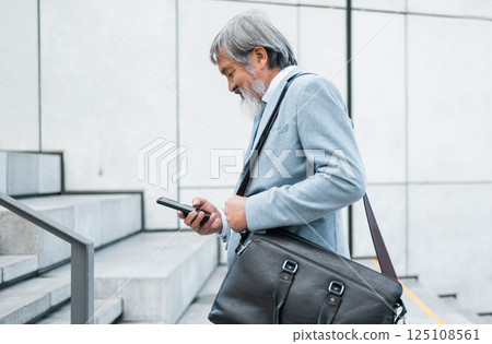 Businessman in Singapore, phone or travel in city with smartphone for 5g network, communication or social media app search. Happy, employee or manager with smile commute to airport, meeting or office 125108561