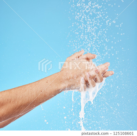 Cleaning hands, water splash and wash for hygiene, healthcare and wellness mockup on a blue studio background. Skin hydration, moisturizing skincare skin and protect from bacteria, germs and disease 125108601