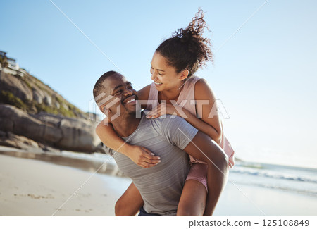 Love, piggy back and black couple on beach walking, smile and happy together, for bonding and outdoor. Romantic, man carry woman or loving on seaside vacation, holiday and romance for relationship. Love, piggy back and black couple on beach walking, smile and happy together, for bonding and outdoor. Romantic, man carry woman or loving on seaside vacation, holiday and romance for relationship. 125108849