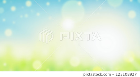 blurry Vibrant blue sky glowing softly with warm sunlight and green field creating dreamy bokeh effect for serene nature background 125108927