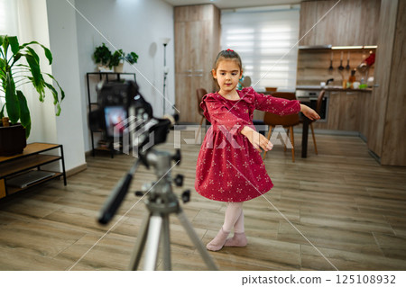 Little dancer performs gracefully in a cozy home space while being filmed for a fun project 125108932