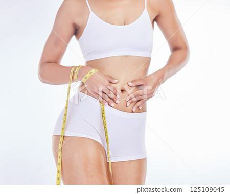 Tape measure, stomach health and woman diet, wellness and weightloss target, belly fat and abdomen on studio white background. Liposuction, tummy tuck and female model, cellulite and body cosmetics 125109045