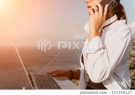 Woman sea laptop. Business woman, freelancer with laptop working over blue sea beach. Happy smiling girl relieves stress from work. Freelance, remote work on vacation, digital nomad, travel concept 125109127