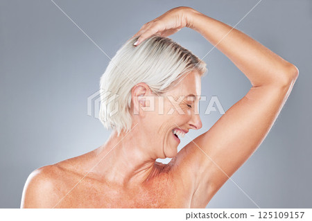 Beauty, hygiene and woman in antiaging with skincare advertising, healthy skin and grooming with pose against grey studio background. Happy, senior model and natural cosmetics with body wellness. 125109157